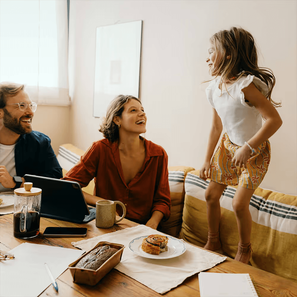 Family laughing together around the breakfast table at home